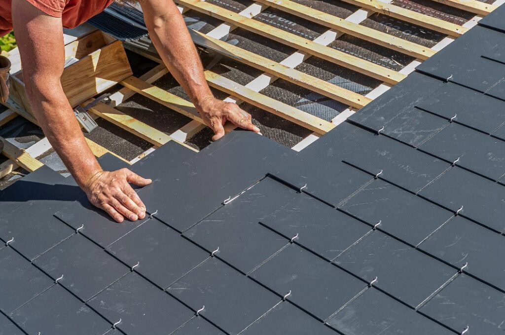 Handwerker installieren ein Schieferdach.