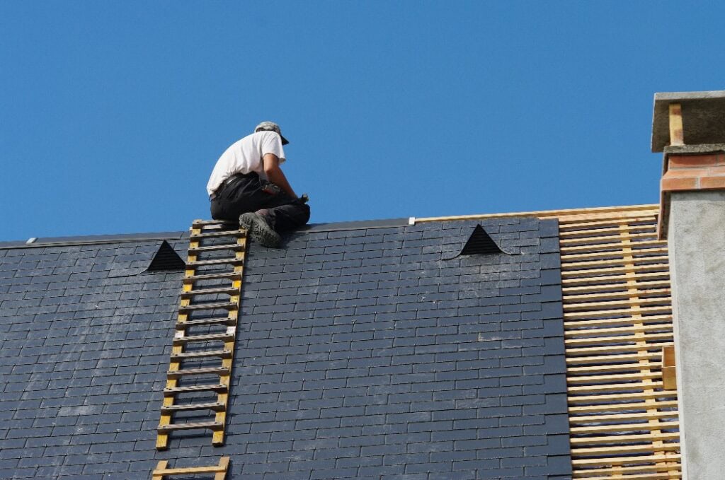 Dachdecker saniert ein Schieferdach